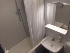 ein weißes Badezimmer mit einem Waschbecken und einem Spiegel in der Unterkunft Apartments Leko in Portorož