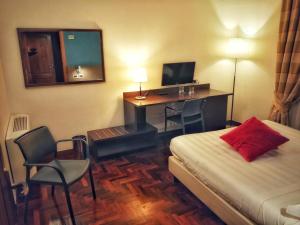 Habitación de hotel con cama y escritorio con ordenador en Locanda Giustini, en Asís