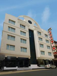 een groot wit gebouw met een bord erop bij Hotel Godwin Deluxe -Near New Delhi Railway Station - Paharganj in New Delhi