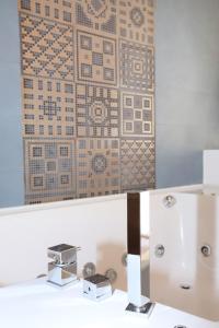 baño con lavabo y pared de azulejos en Unique luxury apartment and rooms, en Roma