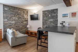 sala de estar con pared de piedra y encimera en A Casa Nuccia Studio by Holiday Solutions, en Como