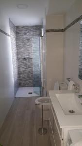a bathroom with a shower and a sink and a stool at Apartamento en Avenida Quevedo in León