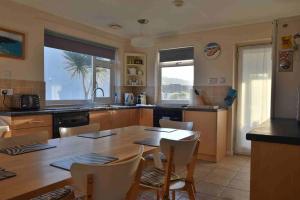 a kitchen with a large wooden table and chairs at Perran Steps in Perranporth