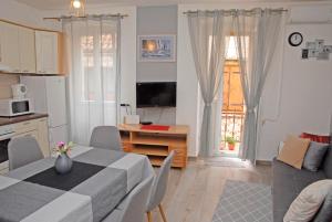 a kitchen and a dining room with a table and a kitchen and a living room at Apartment Tina in Komiža