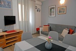a living room with a couch and a table with a television at Apartment Tina in Komiža