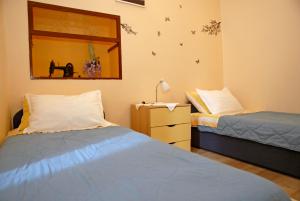 a bedroom with two beds and a mirror at Apartment Tina in Komiža