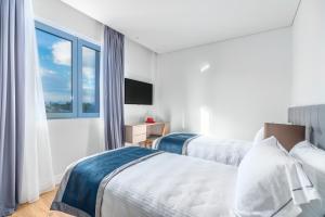 a hotel room with two beds and a window at Glyfada Riviera Hotel in Athens