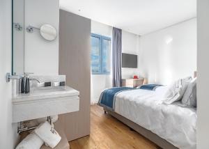 a bedroom with a bed with a sink and a mirror at Glyfada Riviera Hotel in Athens