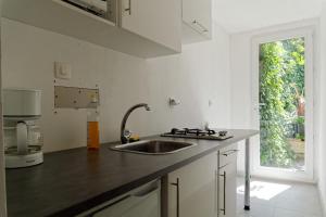 a white kitchen with a sink and a window at Appartement de Plage in Bréhec