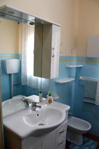 a bathroom with a sink and a mirror and a toilet at Apartment Terrazza Greca in Agrigento