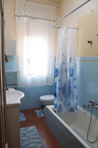 a bathroom with a toilet and a shower curtain at Apartment Terrazza Greca in Agrigento