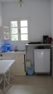 a kitchen with a sink and a table and window at Tatsis Apartments in Masouri
