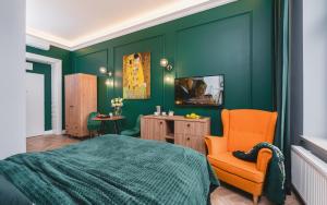 a green bedroom with a bed and an orange chair at Art of Serenity in Krakow