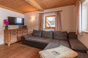 a living room with a couch and a flat screen tv at Berggasthof Staudachstub'n in Kirchberg in Tirol