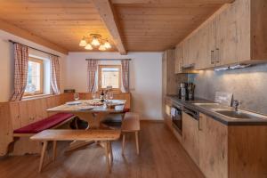 a kitchen with wooden cabinets and a wooden table at Berggasthof Staudachstub'n in Kirchberg in Tirol