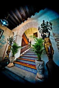
a staircase leading up to a large ornate staircase at Hotel Condes de Castilla in Segovia
