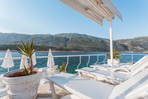 balkon z krzesłami i widokiem na wodę w obiekcie Club Çapa Hotel w Kaş