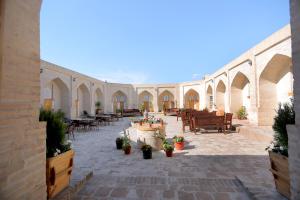 a courtyard with tables and chairs and potted plants at Muso To'ra in Khiva