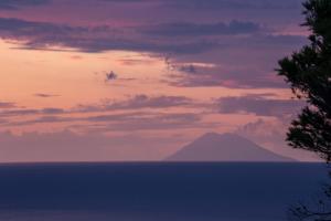 a view of a mountain in the ocean at sunset at Hotel Santa Chiara in Capo Vaticano