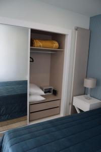 een kleine slaapkamer met een bed met een spiegel bij magnifico apartamento in Albufeira