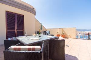 una mesa y sillas en un patio con vistas al océano en Playa San Juan 1 - Two Bed Penthouse, en Playa de San Juan