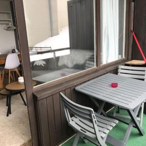 a white table and a chair on a balcony at Charmant studio cabine COCOON à 100 m des pistes in Chamrousse
