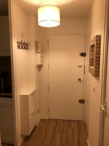 a hallway with a white door and a refrigerator at Charmant studio cabine COCOON à 100 m des pistes in Chamrousse +34 photos