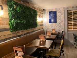 a restaurant with two tables and a green wall at Strawberry Bank Hotel, NEC in Meriden