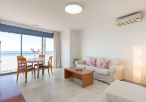 ein Wohnzimmer mit einem Sofa und einem Tisch in der Unterkunft Apartamentos Varadero Sea View & Spa in La Cala del Moral