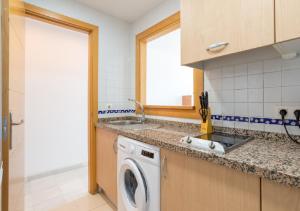 a kitchen with a sink and a washing machine at Apartamentos Varadero Sea View in Cala del Moral +128 photos