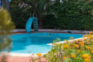 a blue swimming pool with a blue slide in it at Oasis Green Villa in Palermo