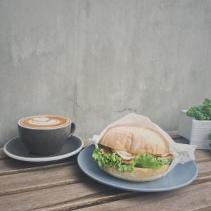un sándwich en un plato junto a una taza de café en Timeline cafe studio en Longjing
