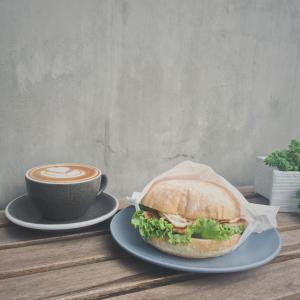 a sandwich on a plate next to a cup of coffee at Timeline cafe studio in Longjing