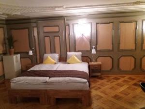 a bedroom with a large bed with two yellow pillows at Hotel Garni Frohsinn in Uttwil