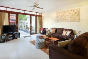 a living room with a couch and a tv at Villa Nova in Legian