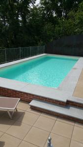 a swimming pool with a bench next to a brick wall at Villa Durando in Mondovì