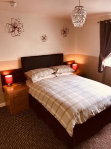 a bedroom with a bed and two lamps and a chandelier at Spalite Hotel in Gloucester