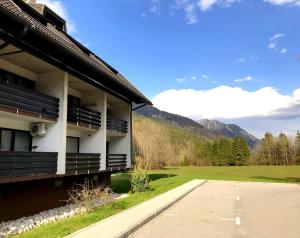 un edificio con le montagne sullo sfondo di Apartment Loyd, Kranjska Gora - studio a Kranjska Gora