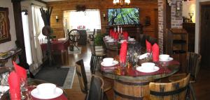 a dining room with wooden tables and chairs with red candles at Gîte Aux Traditions in Saint-Jean-des Piles