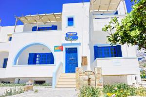 une maison blanche avec des portes et des escaliers bleus dans l'établissement Aegean View Studios, à Lefkos Karpathou
