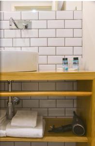een badkamer met een wastafel en een plank met handdoeken bij Spot Apartments Ceuta in Porto
