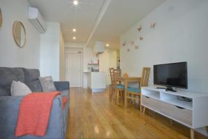 a living room with a couch and a flat screen tv at Spot Apartments Ceuta in Porto