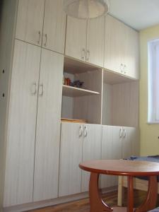 a kitchen with white cabinets and a table at Berneński Zakątek in Charzykowy