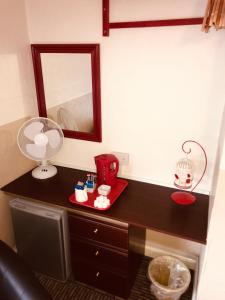 een kamer met een bureau met een spiegel en een lamp bij Spalite Hotel in Gloucester