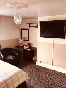 a hotel room with a bed and a flat screen tv at Spalite Hotel in Gloucester