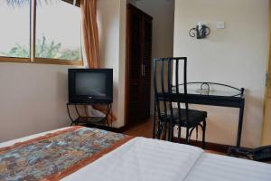 a bedroom with a bed and a tv and a chair at Rates Hotel Mbale in Mbale