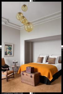 a bedroom with a large bed with an orange blanket at Monastere de Brucourt in Brucourt