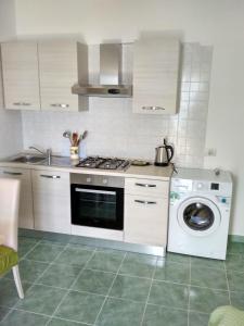 een keuken met een fornuis en een wasmachine bij La casa Verde in Ischia
