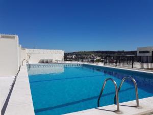 a large blue swimming pool on top of a building at Costa Terrace in Costa da Caparica