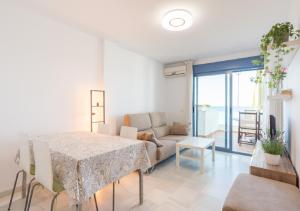 ein Wohnzimmer mit einem Tisch und einem Sofa in der Unterkunft Apartamentos Varadero Sea View & Spa in La Cala del Moral